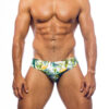 Men's swimwear, slip style, worn by a man, front view, green floral pattern with some yellow flowers.