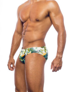 Men's swimwear, slip style, worn by a man, side view, green floral pattern with some yellow flowers.