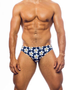 Men's swimwear, slip style, worn by a man, front view, all-over design with white daisies on a blue background